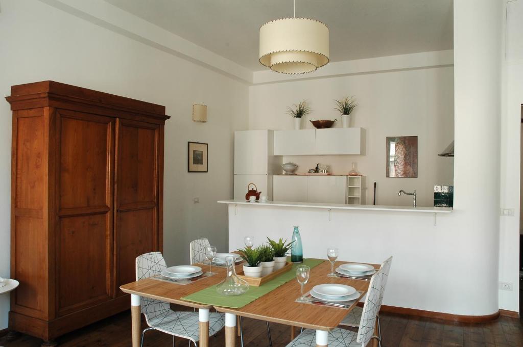 comedor con mesa de madera y sillas en De Cecco Apartments, en Florencia