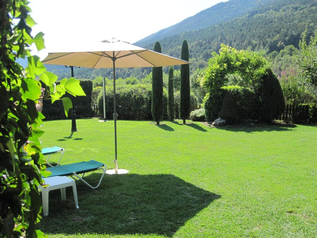 a picnic table and an umbrella in a field at Hostal Cal Batista in Bagá