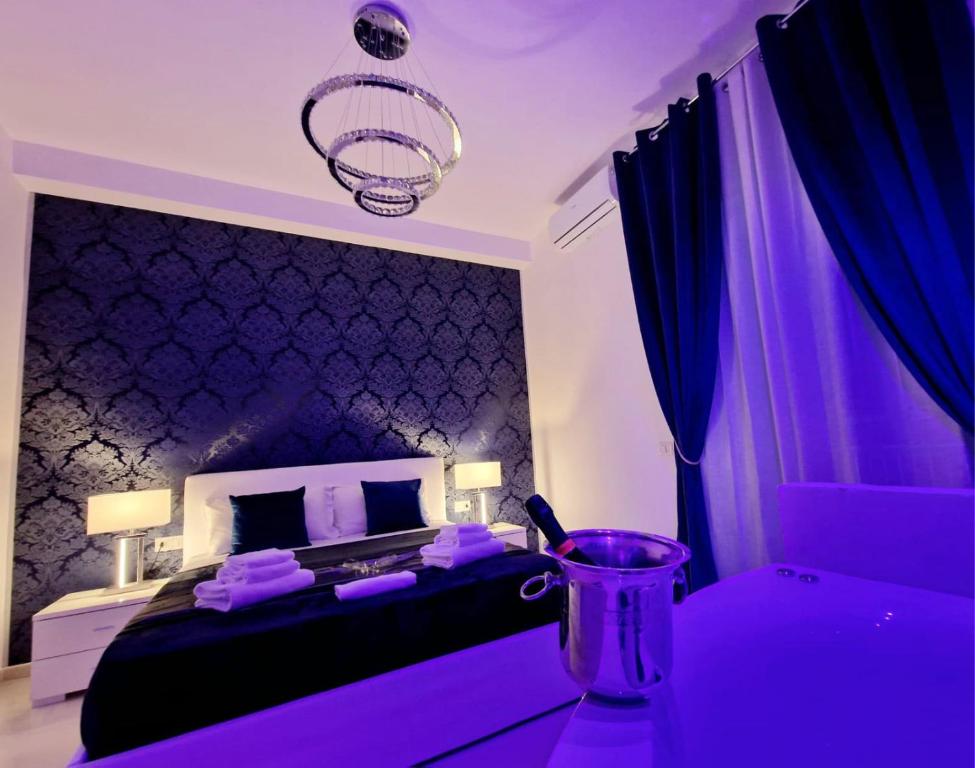 una camera da letto viola con letto e illuminazione viola di Maschio Angioino Suite a Napoli