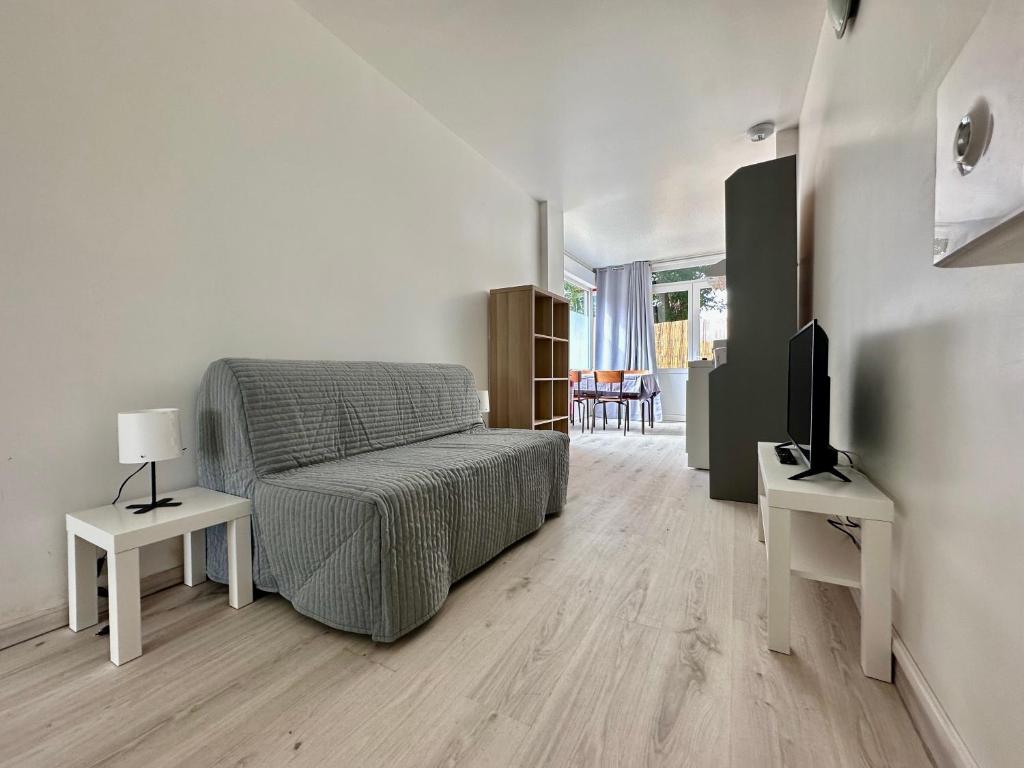 1 dormitorio con 1 cama, 2 mesas y TV en 001 T2 Immeuble Persévérance, en Conflans-en-Jarnisy