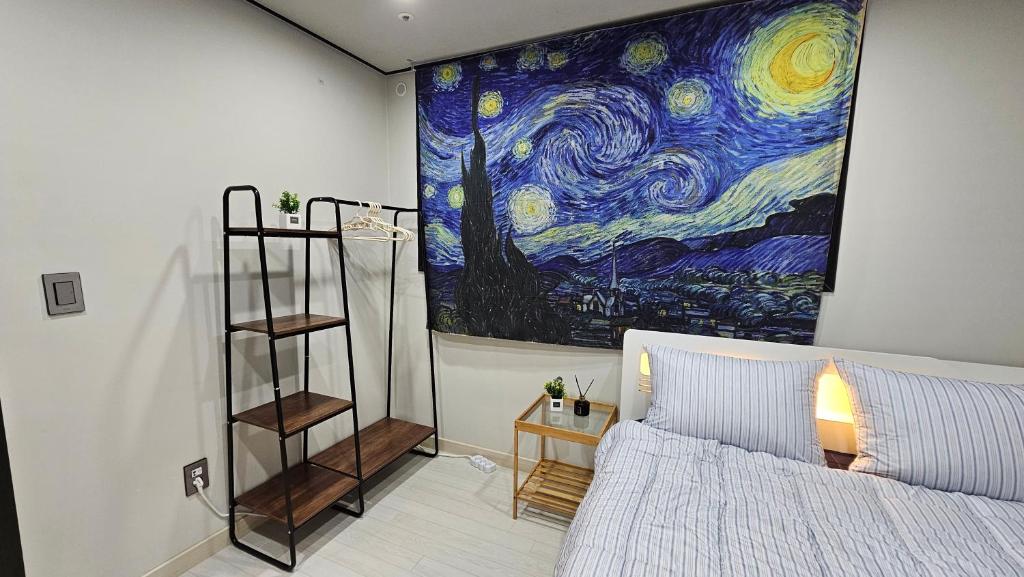 een slaapkamer met een schilderij van de sterrennacht bij Stary Night at Hwagok - Gimpo Airport in Seoul