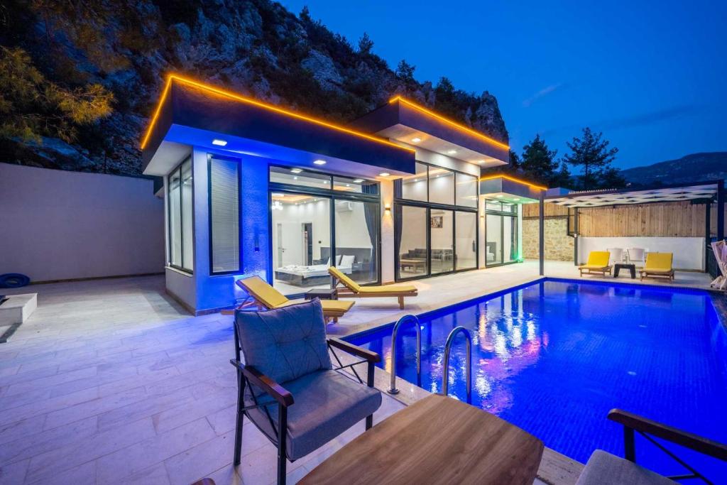 a villa with a swimming pool and a house at Villa Huzurlu in Kaş