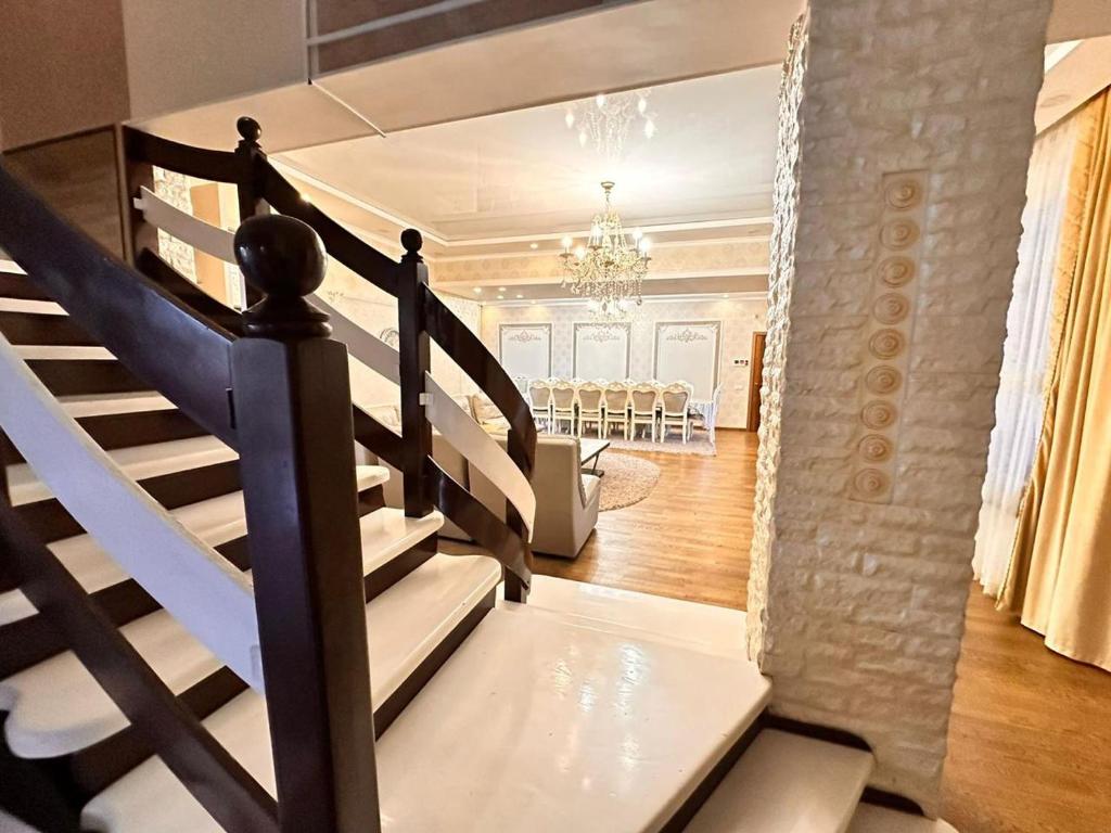 una escalera en una casa con un comedor en el fondo en French Villa Provance en Almaty