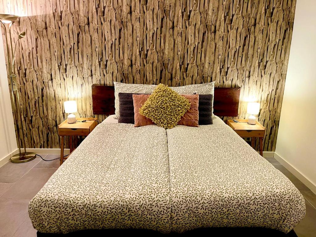 ein Schlafzimmer mit einem großen Bett mit zwei Lampen an Tischen in der Unterkunft Gasterij Hotel Dennenoord in Boxtel