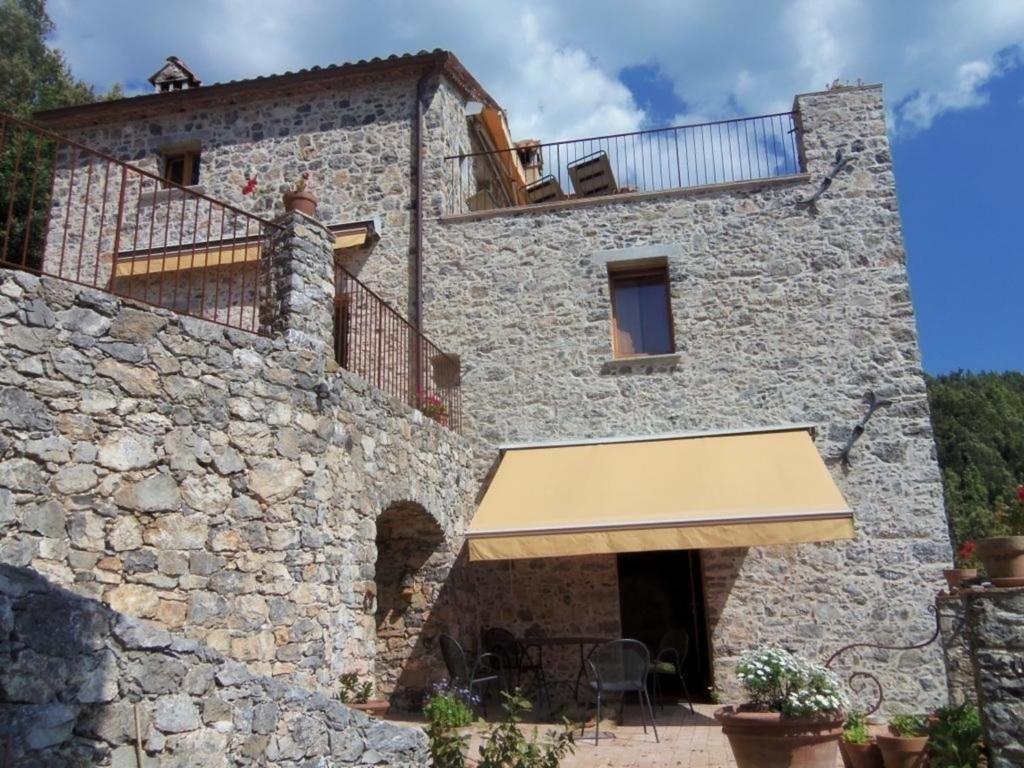 uma vista para o exterior de um edifício de pedra com uma varanda em Schönes Appartement in Tortorella mit Terrasse und Garten em Tortorella
