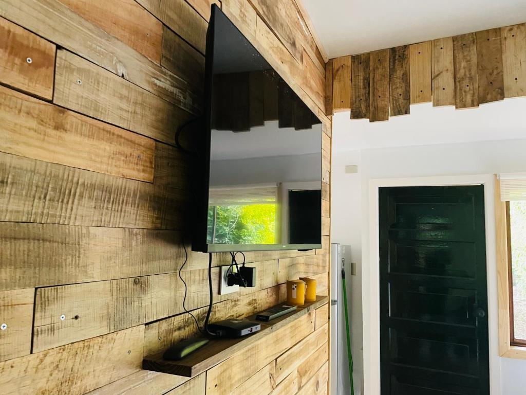 a flat screen tv on a wooden wall in a room at Cabaña céntrica en Temuco in Temuco