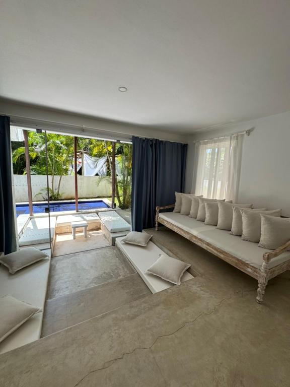 a living room with a couch and a large window at La Réserve Villa REPOUSO PARAISO in Pipa