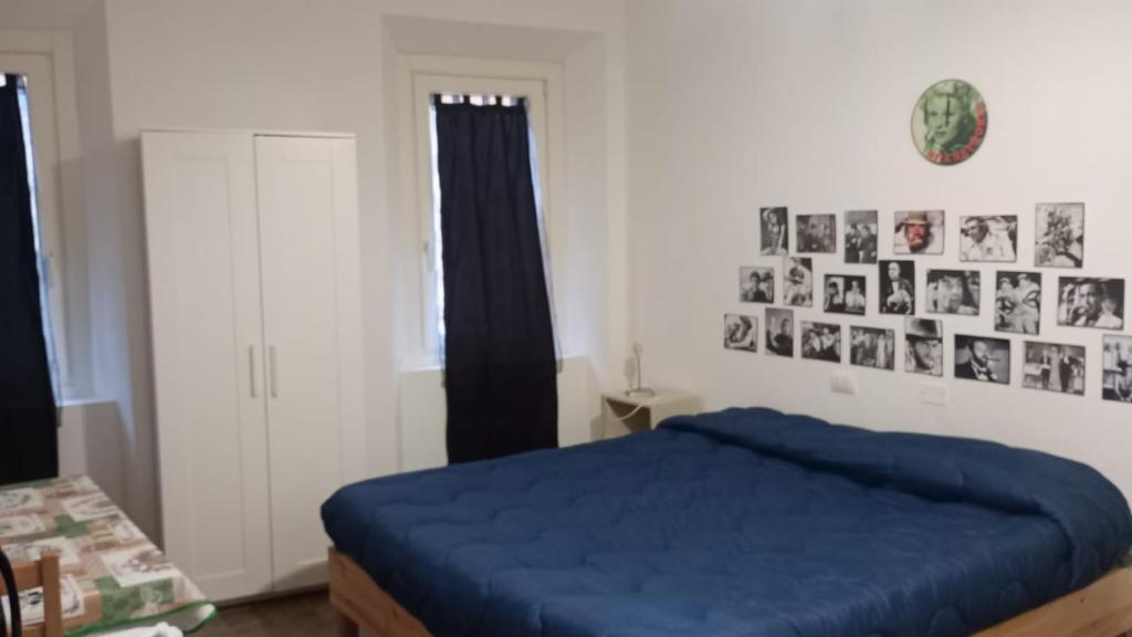 a bedroom with a blue bed and pictures on the wall at porta merlonia house minimono in Forlì