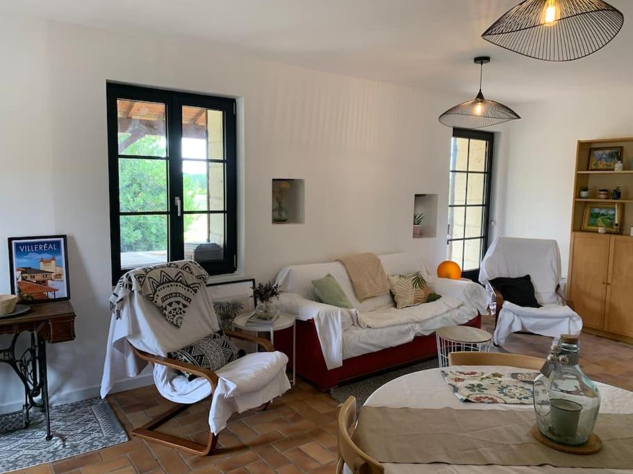 un salon avec un canapé, des chaises et une table dans l'établissement Gite à la campagne, à Saint-Eutrope-de-Born