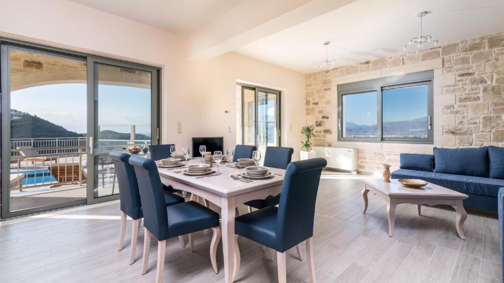 a dining room with a table and chairs and a couch at Villa Ovgoro in Kamilari