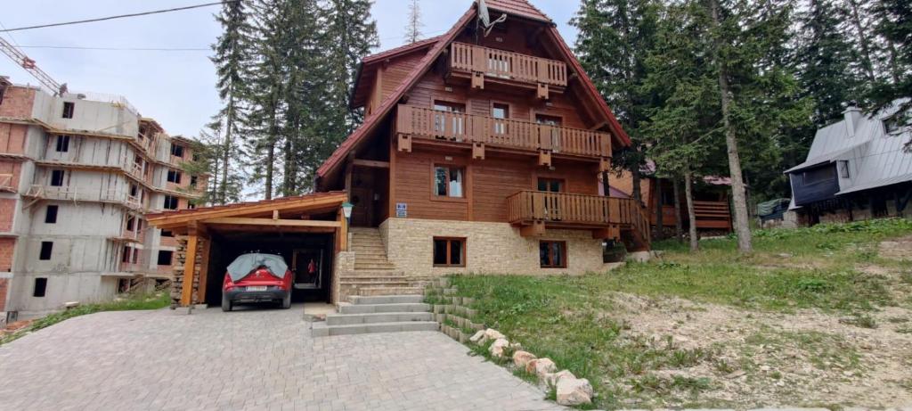 a house with a car parked in front of it at Apartmani Nono in Jahorina