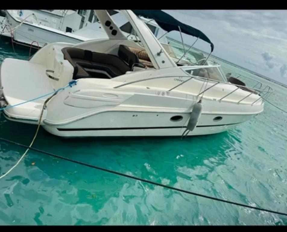 un bote blanco sentado sobre el agua en Residencia altamar 1 habitación, en Boca Chica