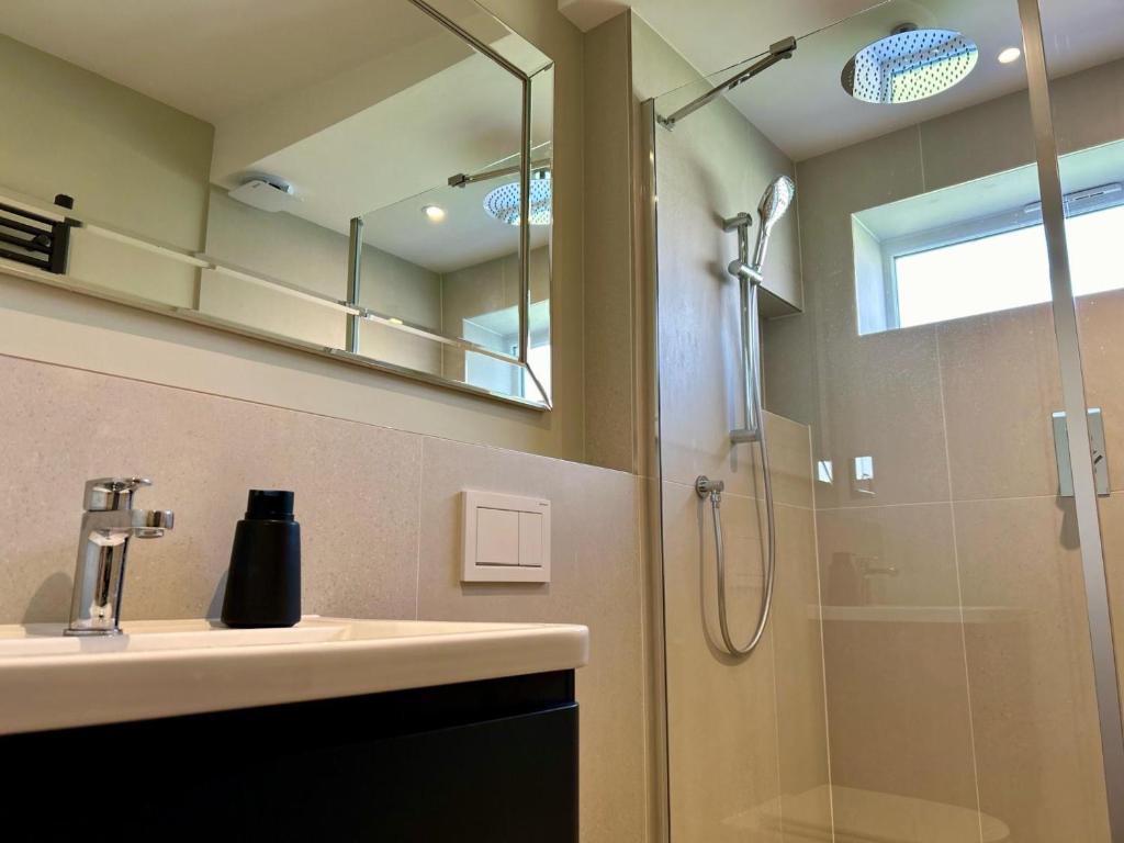 a bathroom with a sink and a shower at White Oaks Sussex in Twineham