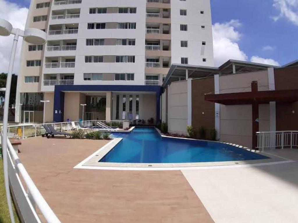 a swimming pool in front of a large building at Apartamento Charme Benfica in Fortaleza
