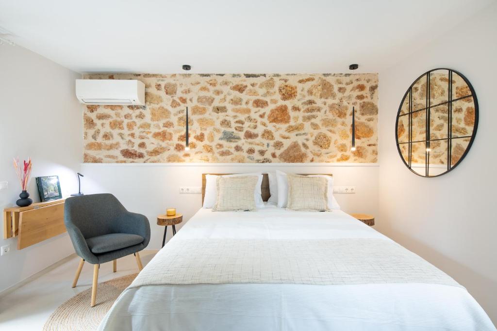 um quarto com uma cama branca e uma cadeira azul em Kifissia Studio em Atenas
