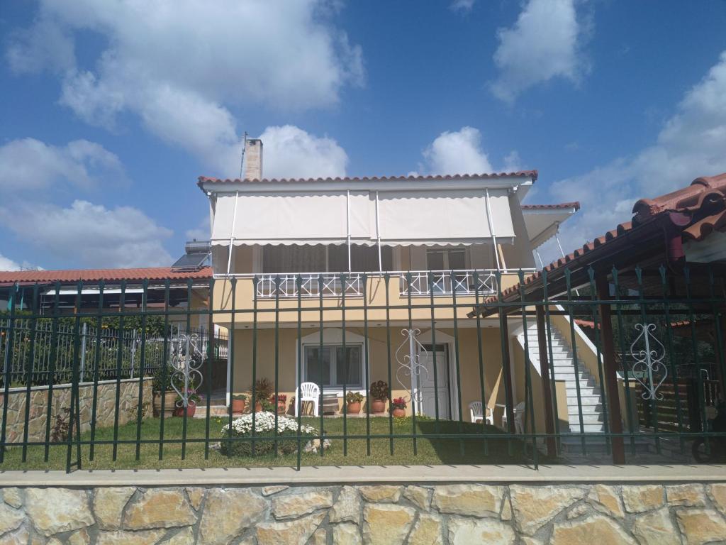 um edifício com uma cerca em frente em Villa Valeria em Magoúla