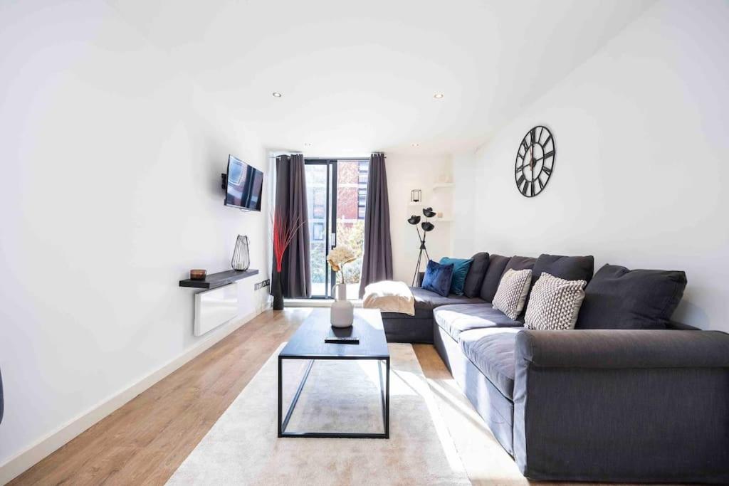 uma sala de estar com um sofá e uma mesa em Stylish 1 BR Apartment Near Shoreditch - 10 Min Walk em Londres