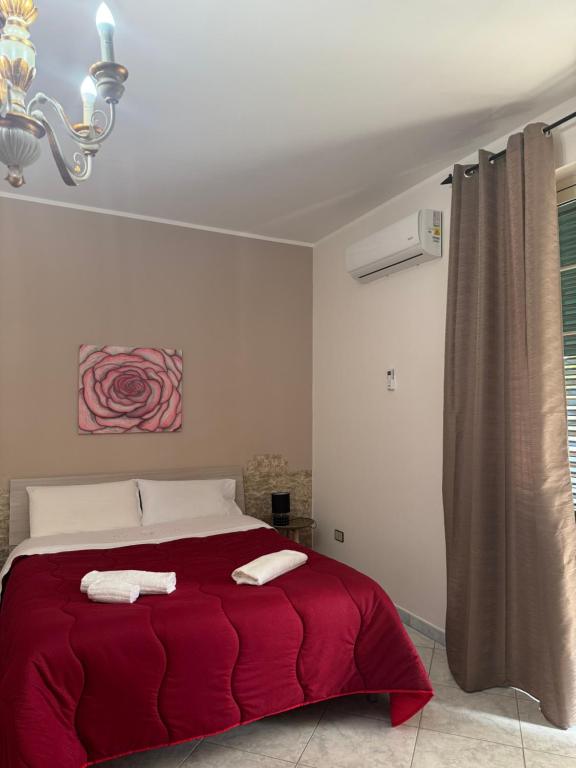 a bedroom with a red bed with two towels on it at B&B Rose Antiche Sicily in Partinico