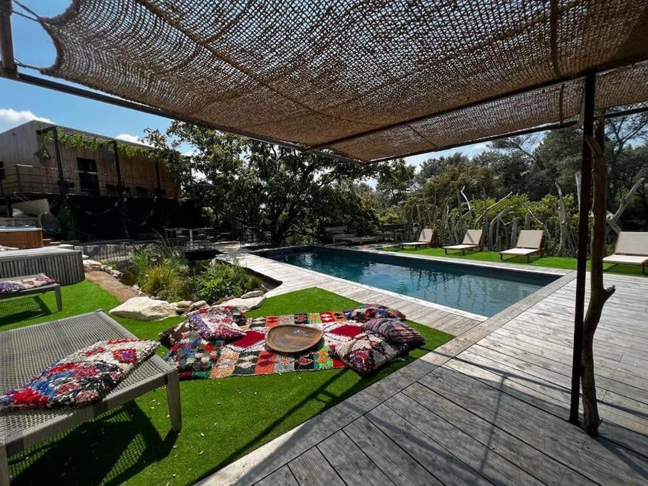 une arrière-cour avec une piscine et une terrasse avec une table dans l'établissement La Villa Bali *****, à Nîmes
