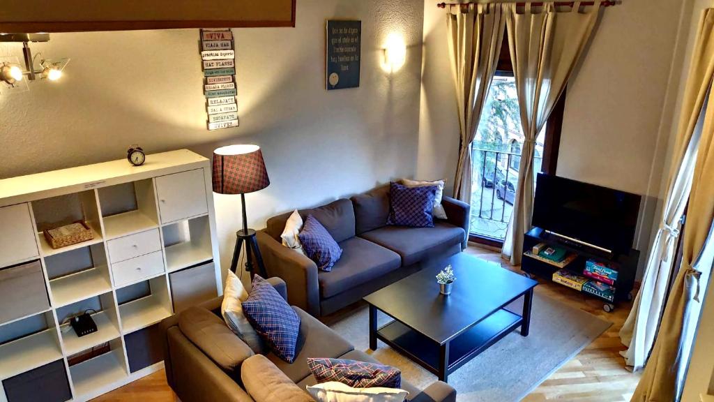 uma sala de estar com um sofá e uma mesa em Apartamentos GO - Tordesillas House nas Tordesilhas
