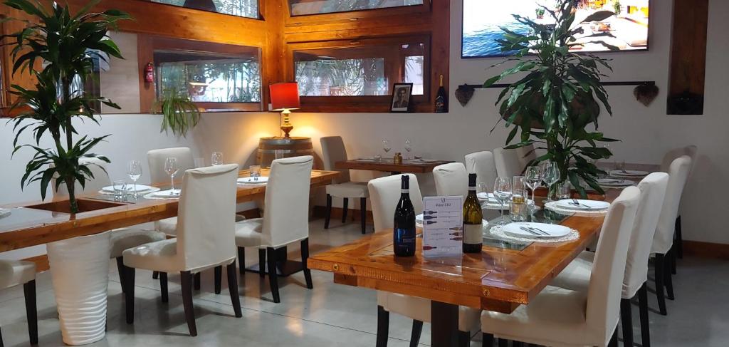 Villa Alba Boutique Hotel في بيسكارا: غرفة طعام مع طاولات خشبية وكراسي بيضاء