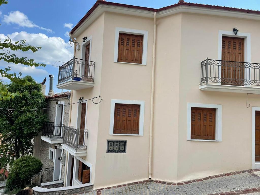 a white building with brown doors and balconies at Arachova Dream in Arachova