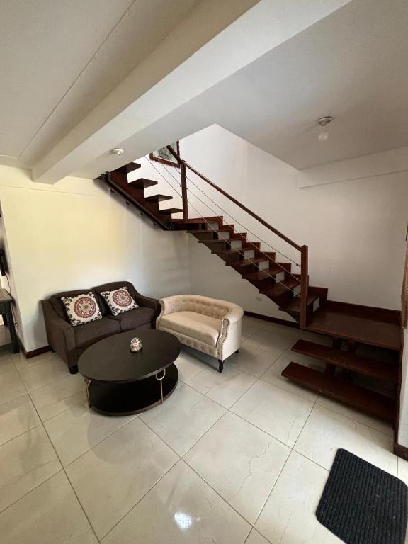 - un salon avec un canapé et un escalier dans l'établissement Refugio colonial y acogedor., à San Miguel Morazán