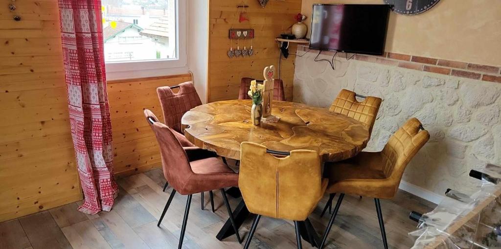 einen Holztisch und Stühle in einem Zimmer in der Unterkunft appartement Gérardmer proche lac , borne vidéo, espace exterieur in Gérardmer