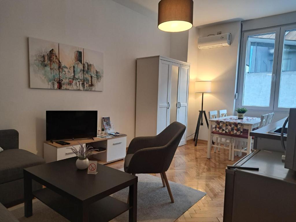 uma sala de estar com um sofá, uma televisão e uma mesa em Apartment Major em Belgrado