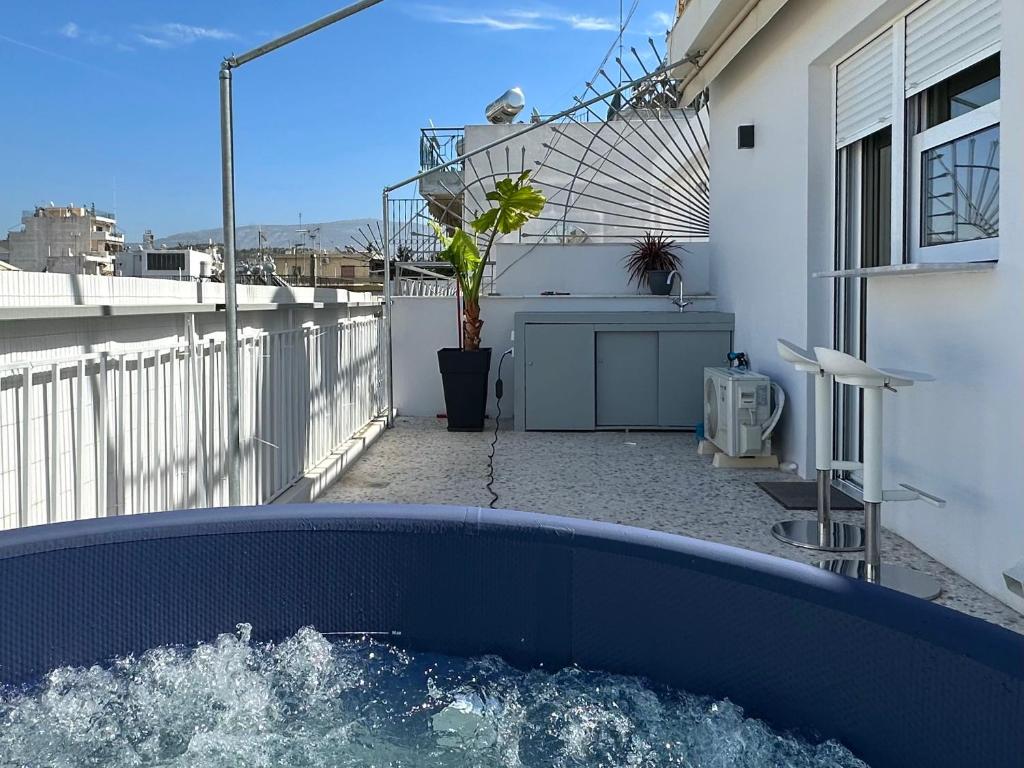 a blue hot tub on the balcony of a house at Cloud 9 - Smart apartment jacuzzi in Athens