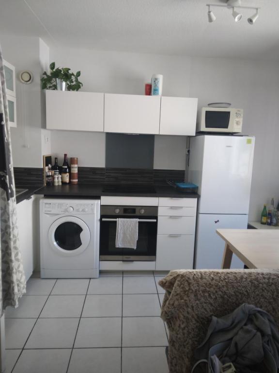 a kitchen with a stove and a washing machine at Appartement Lyon 7 Gerland in Lyon