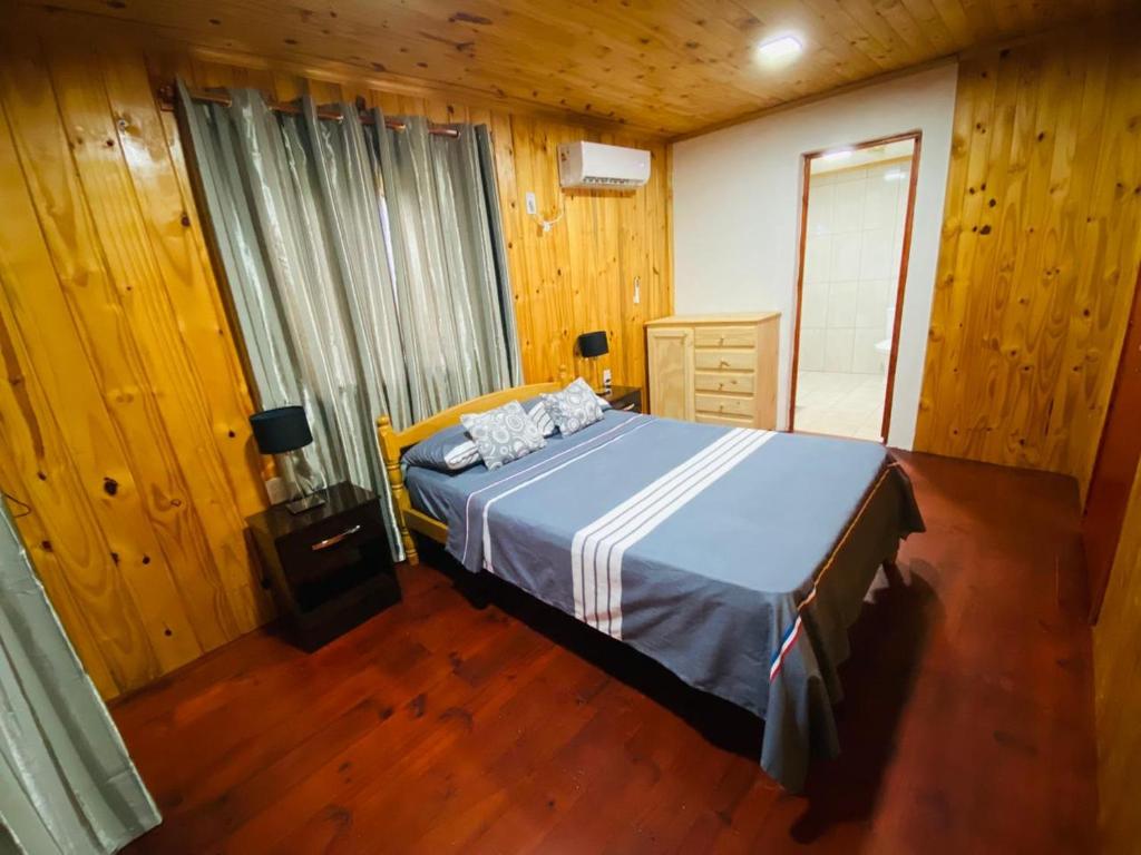 a bedroom with a bed in a wooden room at Alojamiento Matheo in El Soberbio