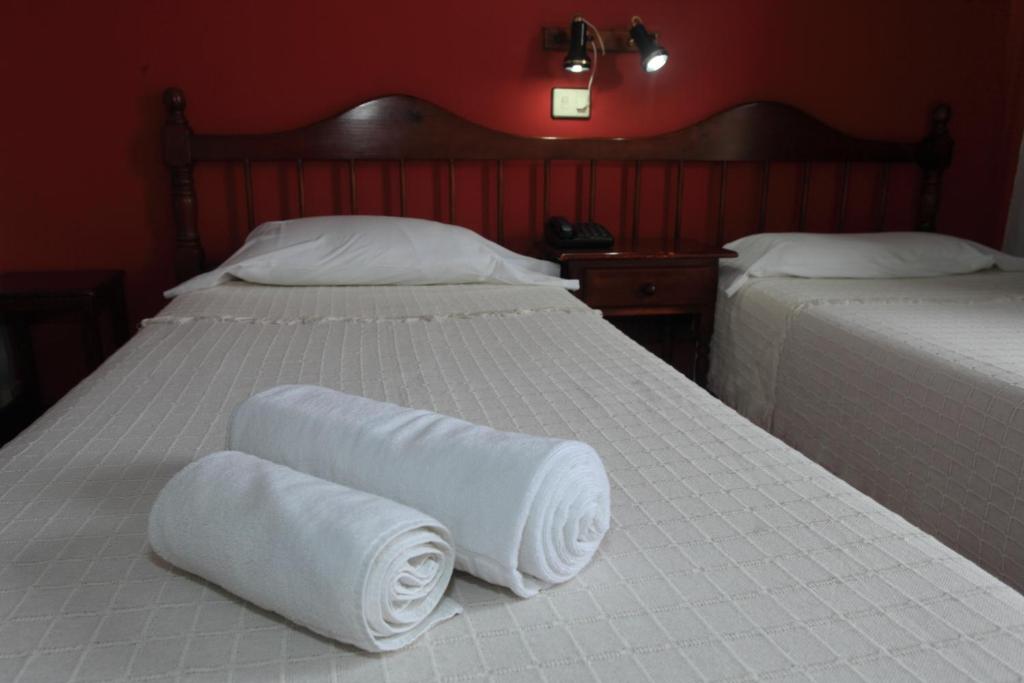 two beds with towels on them in a bedroom at Hotel Ida Inés in Frontera