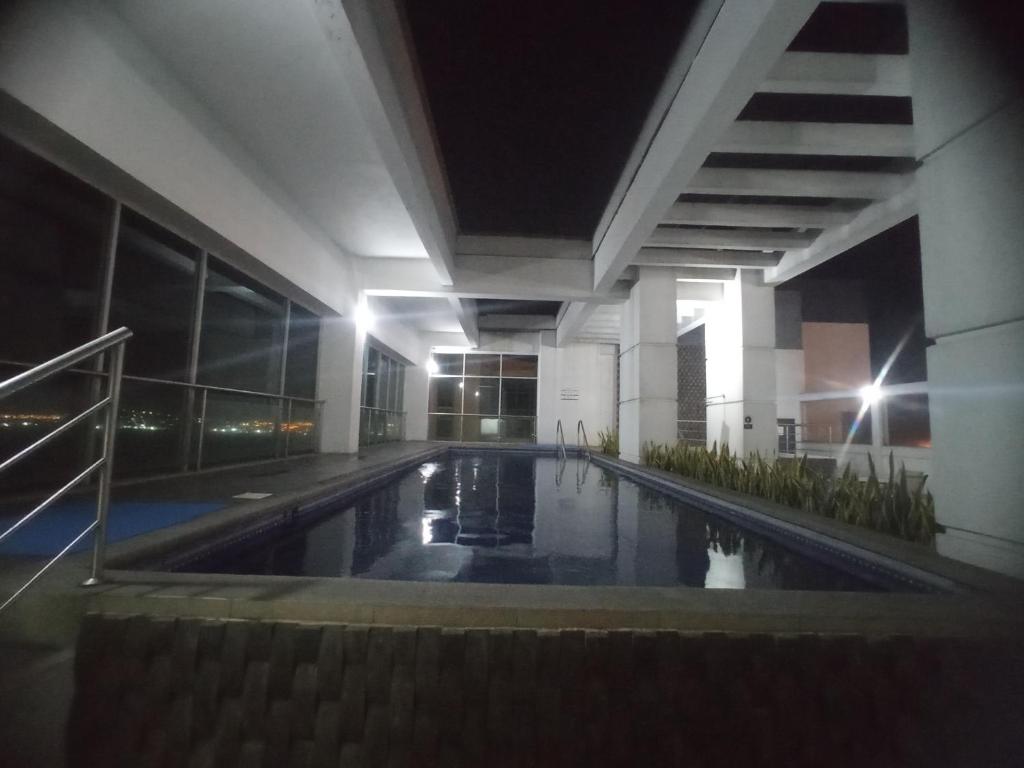 una piscina en medio de un edificio por la noche en Puerto Santana suite, en Guayaquil