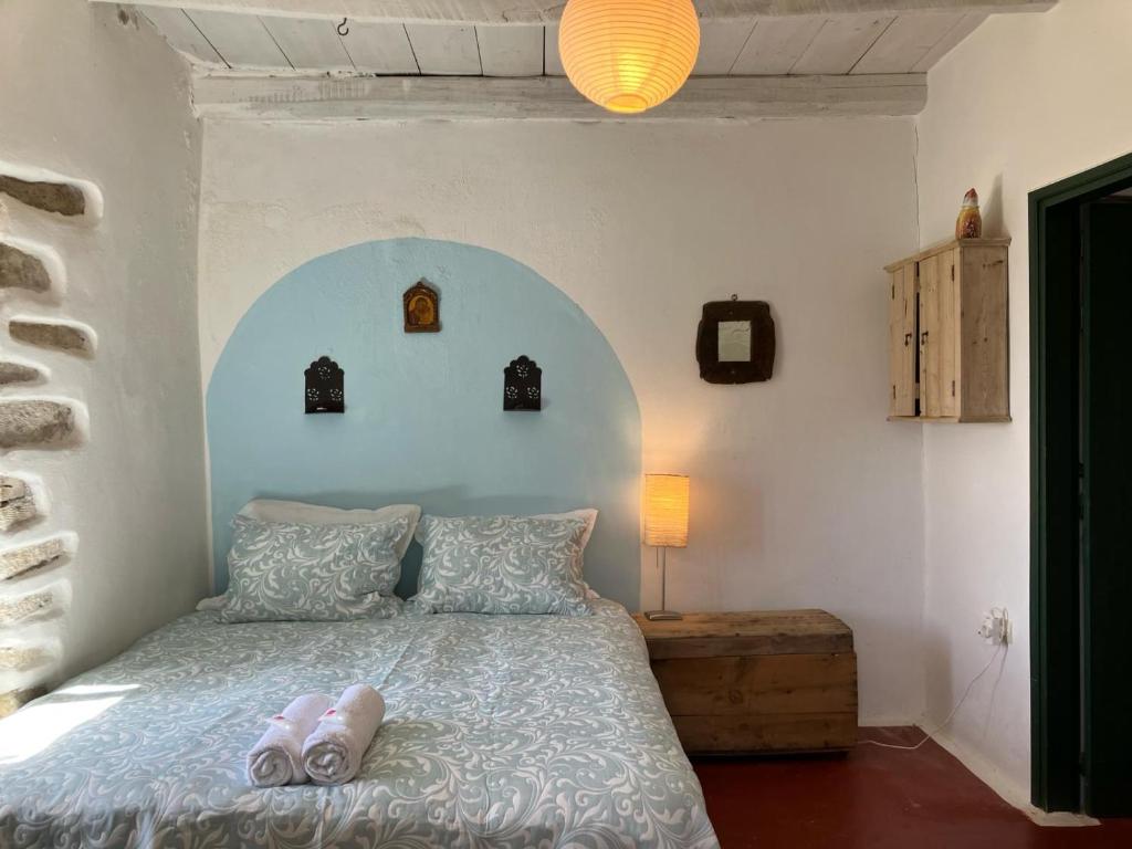 una camera da letto con un letto con due pantofole sopra di Cretan Holiday Cottage a Ierápetra