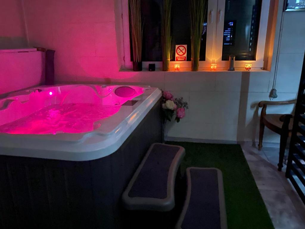 a pink bath tub filled with pink fluids at BM apartament SPA in Legnica
