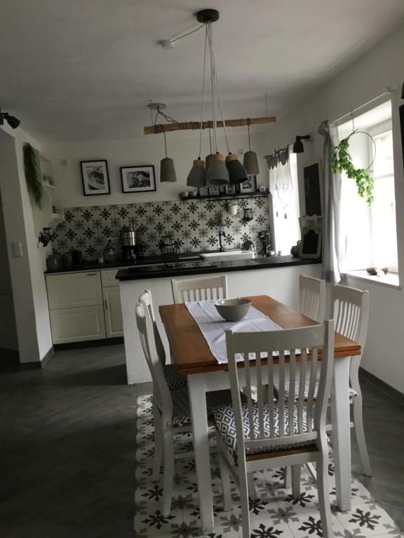 a kitchen with a wooden table and chairs and a table and a table and chairs at Haus Finchen - Alte Näherei in Hückelhoven