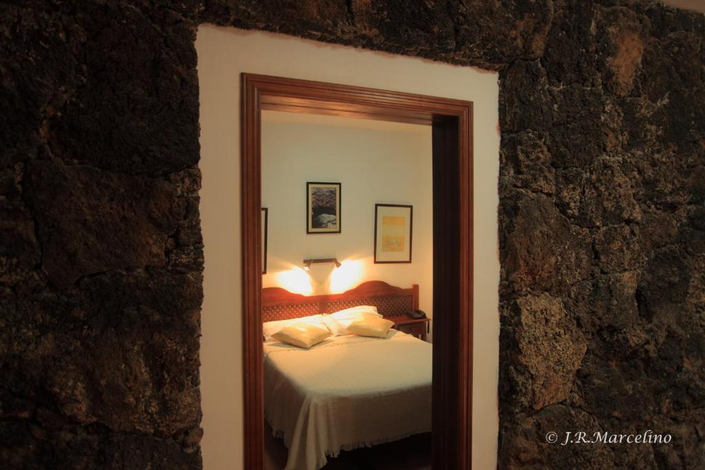 a bedroom with a bed and a mirror at Hotel Ida Inés in Frontera