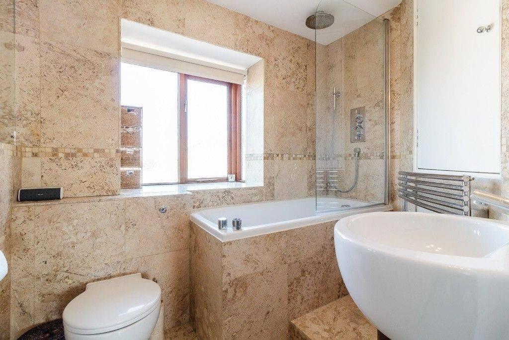 a bathroom with a tub and a toilet and a sink at Good Night Sleep 25 mins from London Bridge and Gatwick Airport in Farnborough