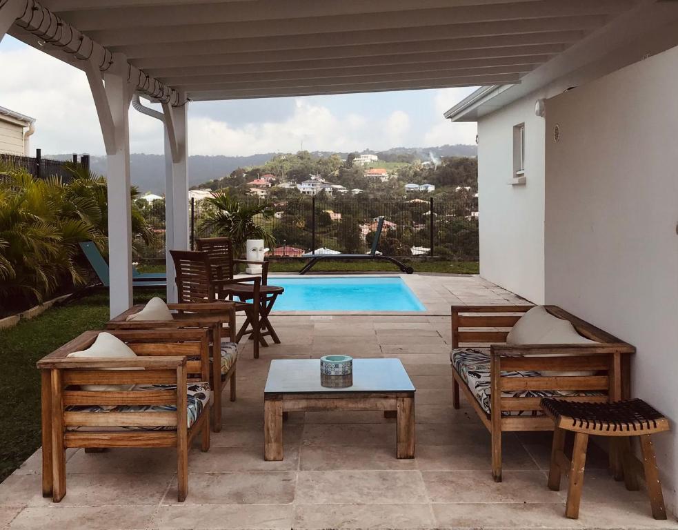 une terrasse avec des chaises, une table et une piscine dans l'établissement Villa TANYA, à Rivière-Salée
