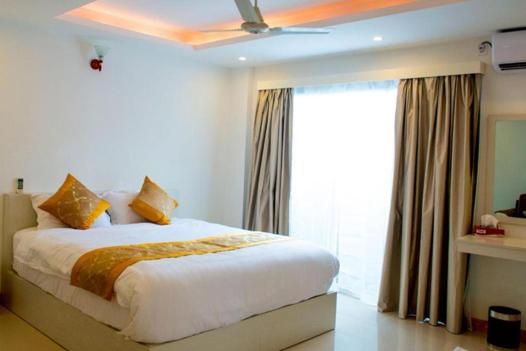 a bedroom with a bed and a large window at Morus Bliss - Divers' Preferred Hotel in Maradhoofeydhoo