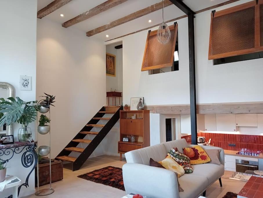 un salon avec un canapé et un escalier dans l'établissement Appartement Vue Notre Dame + extérieur verdoyant, à Marseille
