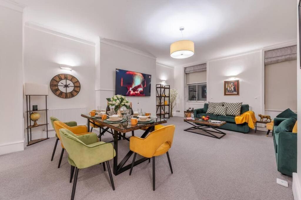 een woonkamer met een tafel en gele stoelen bij Harley Street Spectacular Suites with High Ceilings, High Luxury in Londen