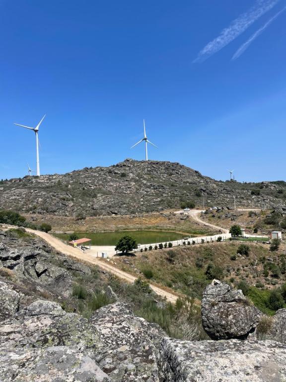 dos turbinas eólicas en la cima de una colina con una carretera en Sabugal Comfort - Central Castelo, en Sabugal