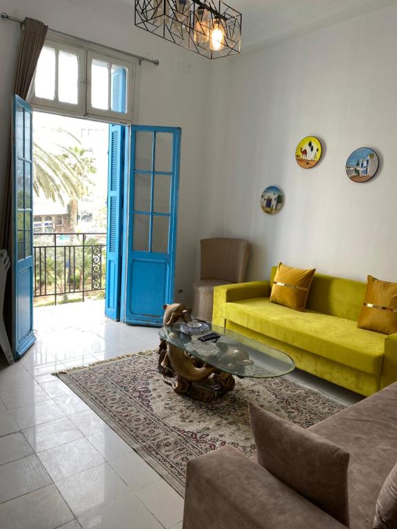 a living room with a yellow couch and a table at Appartement de ville in Tunis
