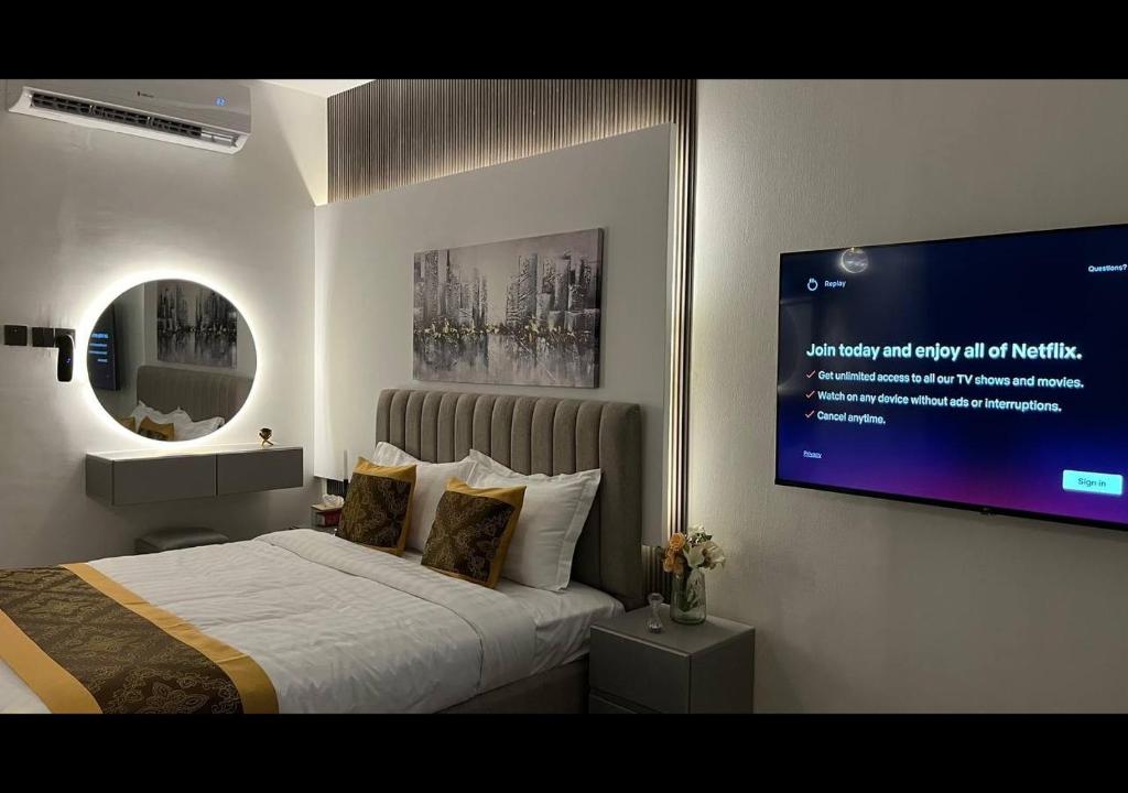 a bedroom with a bed and a tv on the wall at استديو البوليفارد مدخل خاص دخول ذاتي in Riyadh
