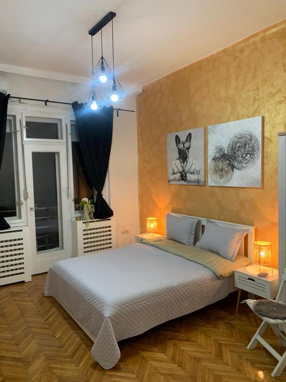 a bedroom with a bed and two pictures on the wall at Apartment Stay in Novi Sad