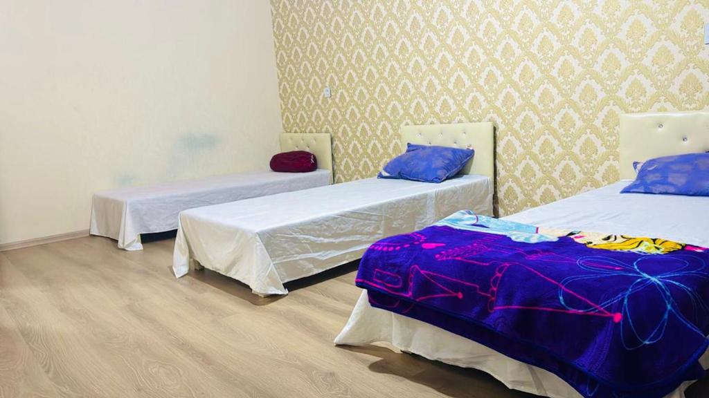 a room with two beds and a wall at Key Explore Hostel Hotel in Baku