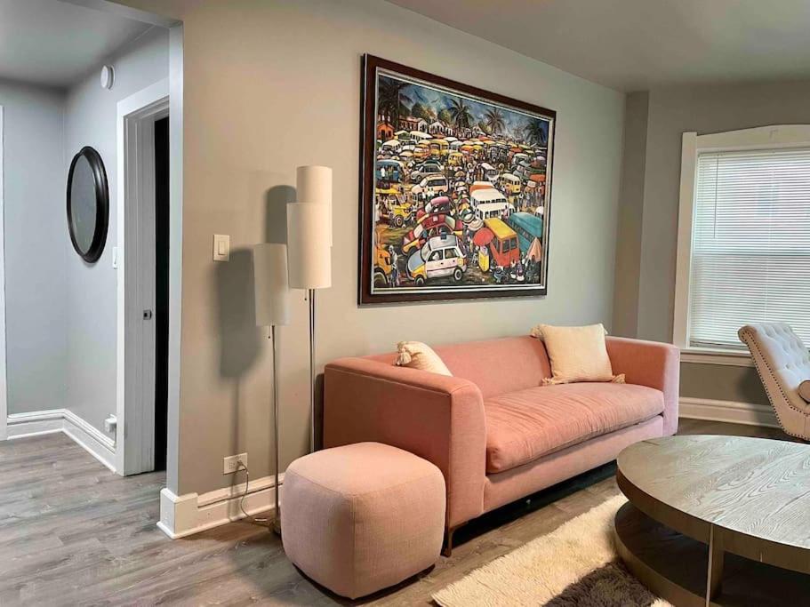 a living room with a pink couch and a table at Cozy Luxury Apt~ near UChicago/HydePark/Lakeshore in Chicago