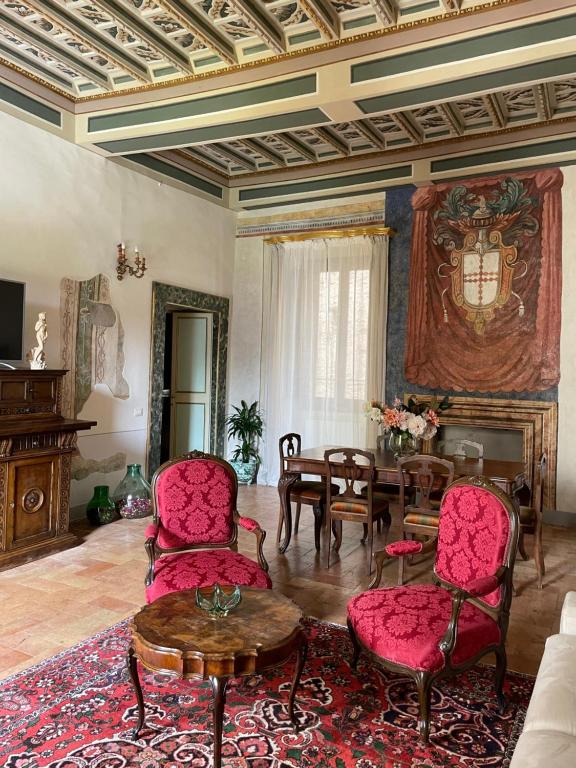 a living room with red chairs and a table at Palazzo Lauri Spoleto in Spoleto